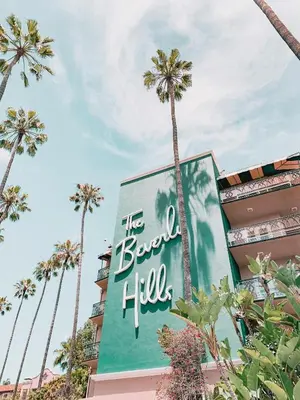 a sign in front of a building with palm trees at Hollywood CHIC Studio with FREE parking in Los Angeles