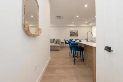 a kitchen and living room with a counter and stools at Stylish Apartments in Glendale with Free Parking in Glendale
