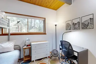 a bedroom with a desk and a bed and a window at Quiet Wooded Retreat in Lake Arrowhead