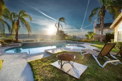 a backyard with a pool with two chairs and a table at The Best View in The City! in Castaic