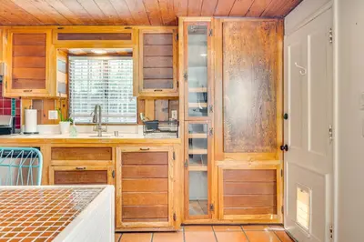 a kitchen with wooden cabinets and a window at Less Than 1 Mi to Venice Beach and Boardwalk! Quiet Cottage in Los Angeles