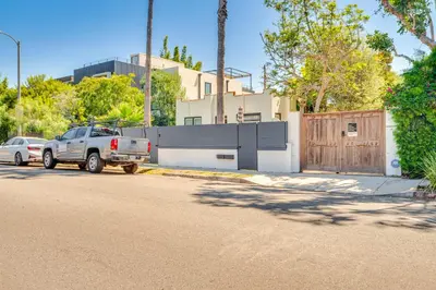 a truck parked in front of a house with a fence at Less Than 1 Mi to Venice Beach and Boardwalk! Quiet Cottage in Los Angeles