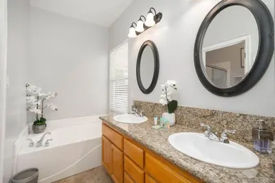a bathroom with two sinks and a tub and a mirror at Central Bliss near parks & shops in Bakersfield
