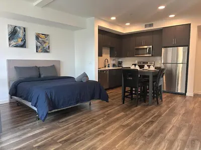 a bedroom with a bed and a table and a kitchen at Awesome Loft at Hollywood FREE Parking in Los Angeles