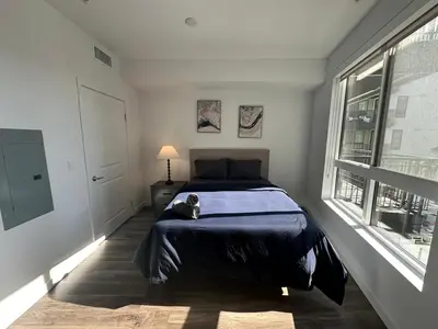 a cat sitting on a bed in a bedroom at Awesome Loft at Hollywood FREE Parking in Los Angeles