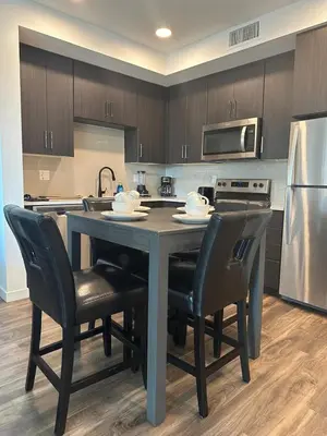 a kitchen with a table with chairs and a refrigerator at Awesome Loft at Hollywood FREE Parking in Los Angeles