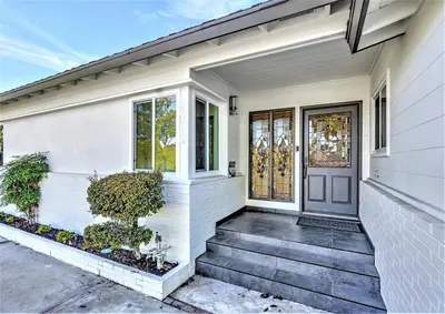 a white house with a front door and stairs at NEW Lux 5BR Villa Near Disney, Knotts, LA, OC with Hot Tub & Games in Fullerton