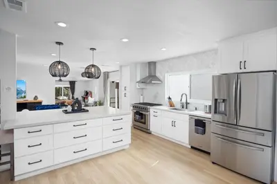 a kitchen with white cabinets and stainless steel appliances at NEW Lux 5BR Villa Near Disney, Knotts, LA, OC with Hot Tub & Games in Fullerton