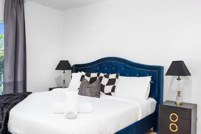 a bedroom with a blue and white bed with pillows at NEW Lux 5BR Villa Near Disney, Knotts, LA, OC with Hot Tub & Games in Fullerton