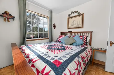 a bedroom with a bed with a quilt on it at Cozy Bear Cottage - Walk to Lake & Village! in Big Bear Lake
