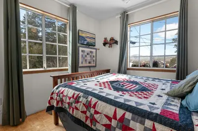 a bedroom with a bed with a quilt on it at Cozy Bear Cottage - Walk to Lake & Village! in Big Bear Lake