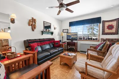 a living room with a couch and a table at Cozy Bear Cottage - Walk to Lake & Village! in Big Bear Lake