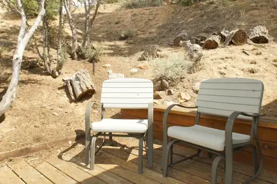 two chairs and a table on a deck at Cozy Bear Cottage - Walk to Lake & Village! in Big Bear Lake