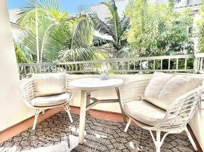 two chairs and a table on a balcony with palm trees at Cozy Resort-Style Experience - Garden View in Los Angeles