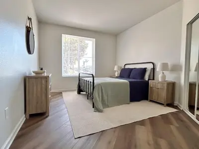 a bedroom with a bed with blue pillows and a window at Big 3BD 2BA Apt with Pool and Gym near Venice Beach in Los Angeles