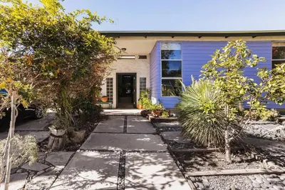 a house with a blue door and trees in front of it at Lovely one bedroom guest house in Encino village in Los Angeles