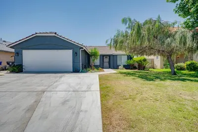 a house with a garage in a yard at Simple Home for Work or Travel in Bakersfield