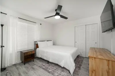 a white bedroom with a bed and a ceiling fan at Simple Home for Work or Travel in Bakersfield