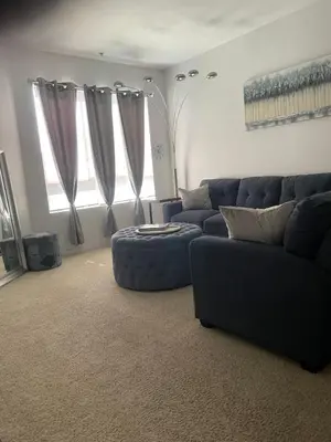 a living room with a blue couch and a ottoman at Tucked in Little Tokyo in Los Angeles