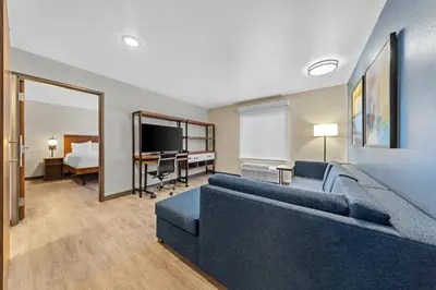 a living room with a couch and a desk at Everhome Suites Ontario in Ontario