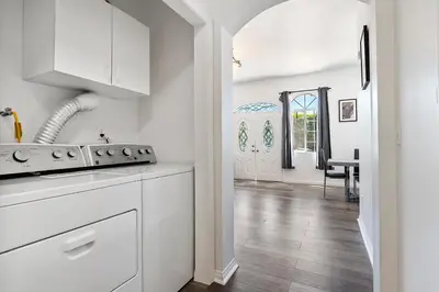 a kitchen with white cabinets and a dining room at Lovely gated 3bedroom & 2 bath unit near Universal studio and Hollywood in North Hollywood