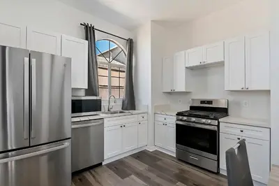 a kitchen with white cabinets and a stainless steel refrigerator at Lovely gated 3bedroom & 2 bath unit near Universal studio and Hollywood in North Hollywood