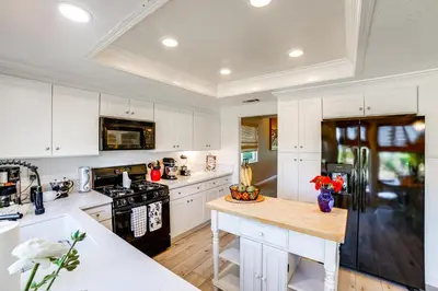 a kitchen with white cabinets and a black refrigerator at Pet-Friendly Riverside Retreat with Private Spa! in Riverside