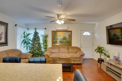 a living room with two couches and a christmas tree at 5 Mi to Coast Centrally Located Long Beach Home! in Long Beach