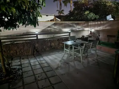a table and chairs on a patio at night at The Coastal Comfort in Oxnard
