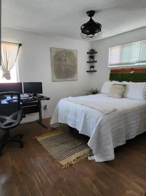 a bedroom with a bed and a desk with a computer at The Coastal Comfort in Oxnard