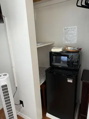 a microwave sitting on top of a black refrigerator at The Hub in Del Aire