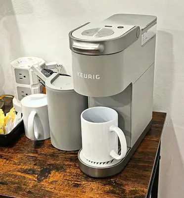 a coffee machine sitting on a counter with a cup at The Hub in Del Aire