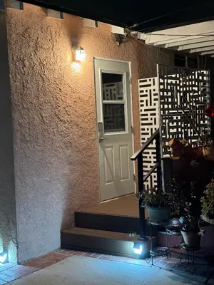 a house with a white door and stairs with plants at The Hub in Del Aire