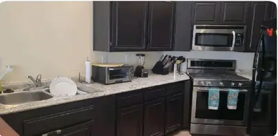 a kitchen with a sink and a stove and a microwave at Be our Guest Hm Tampa in Palmdale
