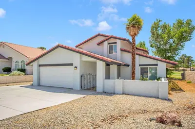 a house with a palm tree in front of it at High Desert Dream on the Fairway WiFi Smart TVs in Victorville