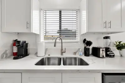 a white kitchen with a sink and a window at Cozy Elegant Oasis With Parking in Los Angeles