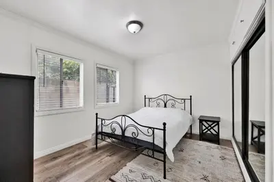 a white bedroom with a bed and a window at Cozy Elegant Oasis With Parking in Los Angeles