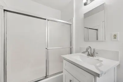 a white bathroom with a shower and a sink at Cozy Elegant Oasis With Parking in Los Angeles