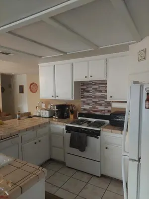 a kitchen with white cabinets and a stove top oven at Lyons lovely house in Hesperia