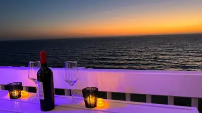 a bottle of wine and two glasses on a table with the ocean at Oceanfront 2BR 2BA with Stunning View 333 in Redondo Beach