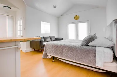 a white bedroom with a bed and a couch at Cozy Private Studio in Granada Hills Near CSUN, Universal in Mission Hills