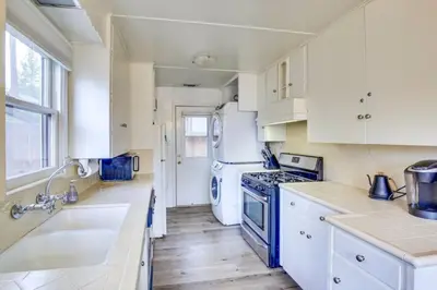 a kitchen with white cabinets and a stove top oven at The Twin Pines Chalet, 2 min to Village, BBQ in Big Bear Lake