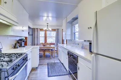 a kitchen with white cabinets and a refrigerator at The Twin Pines Chalet, 2 min to Village, BBQ in Big Bear Lake