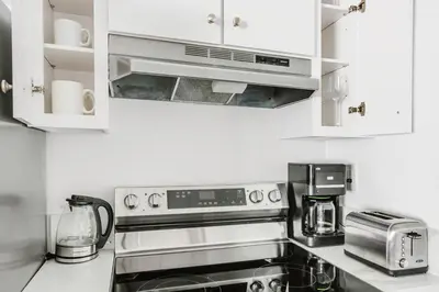 a kitchen with white cabinets and a stove top oven at Blueground Mid-Wilshire pool nr retail LAX-1266 in Los Angeles