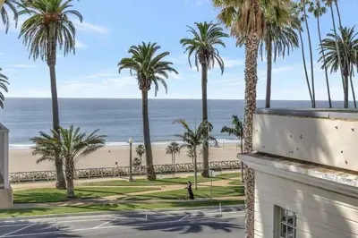 a view of the beach and palm trees from a building at 14 Santa Monica Gorgeous Apartment in Los Angeles