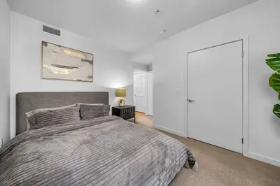 a bedroom with a large bed and white walls at Modern & chic in Heart of Downtown Santa Monica in Los Angeles