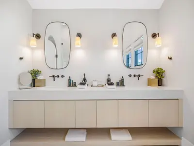 a bathroom with a sink and two mirrors at Villa Camellia in Los Angeles