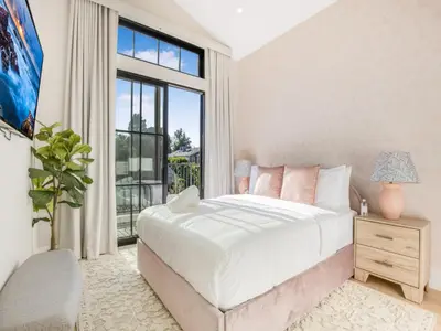a bedroom with a bed and a large window at Villa Camellia in Los Angeles