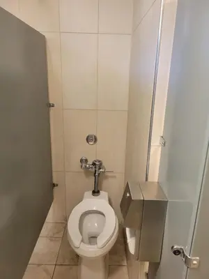 a small bathroom with a toilet in a stall at Randolph Hotel in Huntington Park