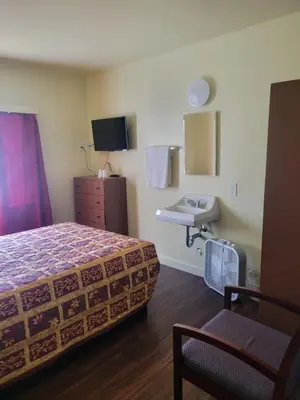a hotel room with a bed and a sink at Randolph Hotel in Huntington Park